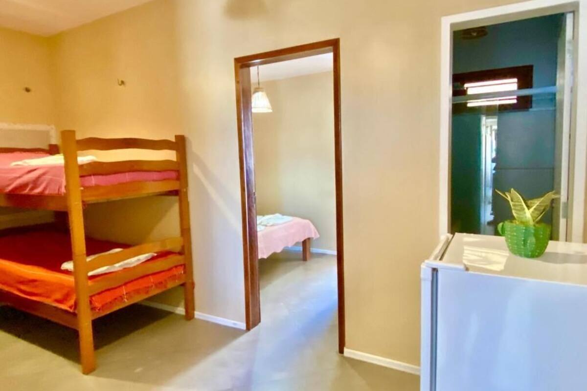 A room with bunk beds, a small desk, and a mirror.