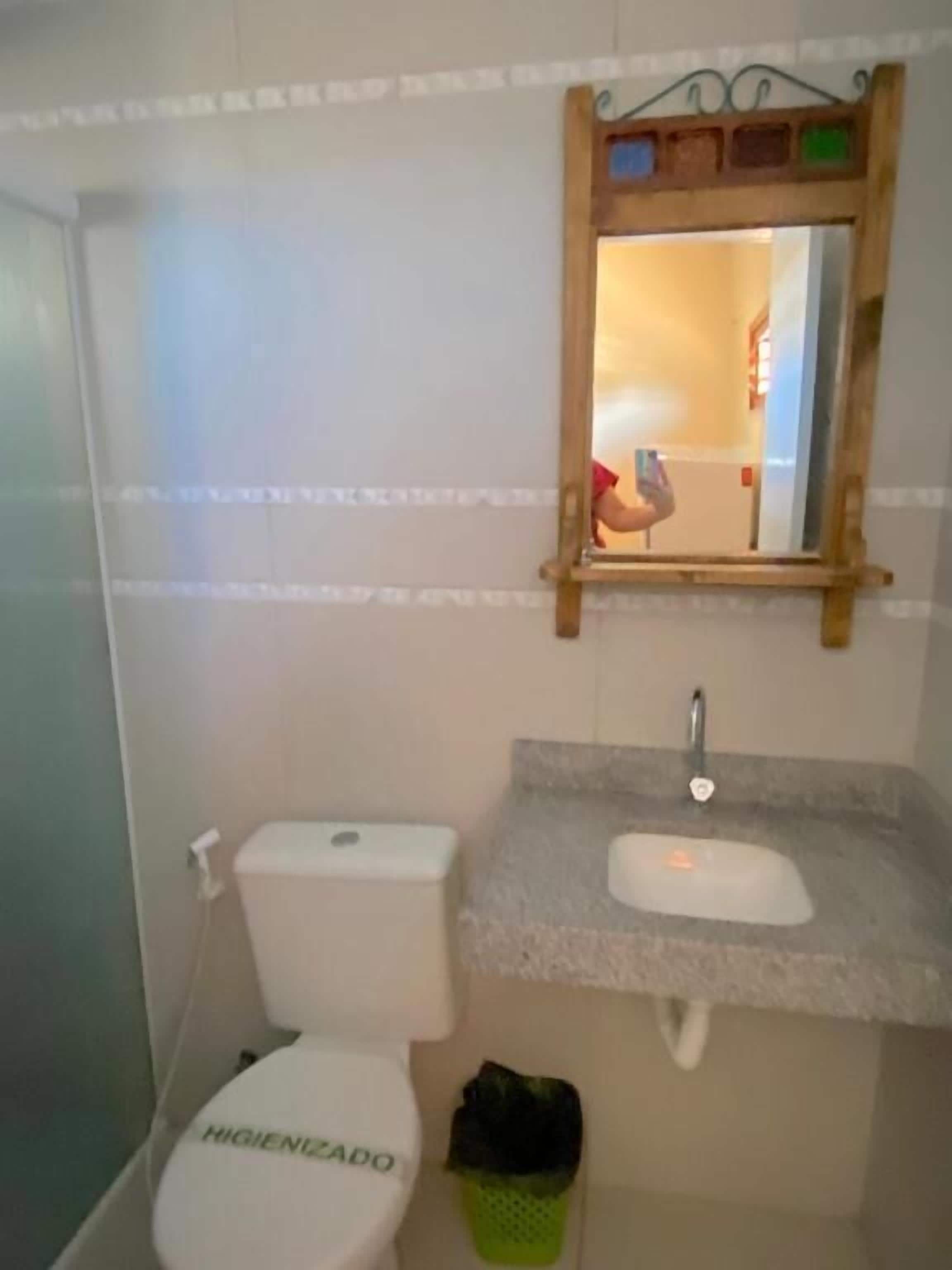 Ein Badezimmer mit Toilette, Waschbecken und Spiegel.