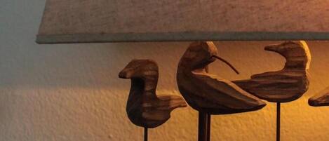 A wooden sculpture of three birds on a stand.