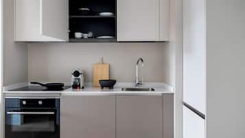 Una cocina moderna con horno empotrado, estufa, lavaplatos y tabla de cortar de madera.