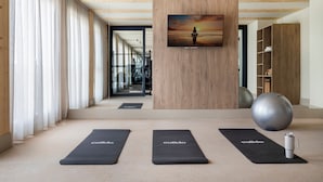 Una palestra moderna con tappetini da ginnastica, una palla grande per esercizi e un quadro motivazionale al muro.