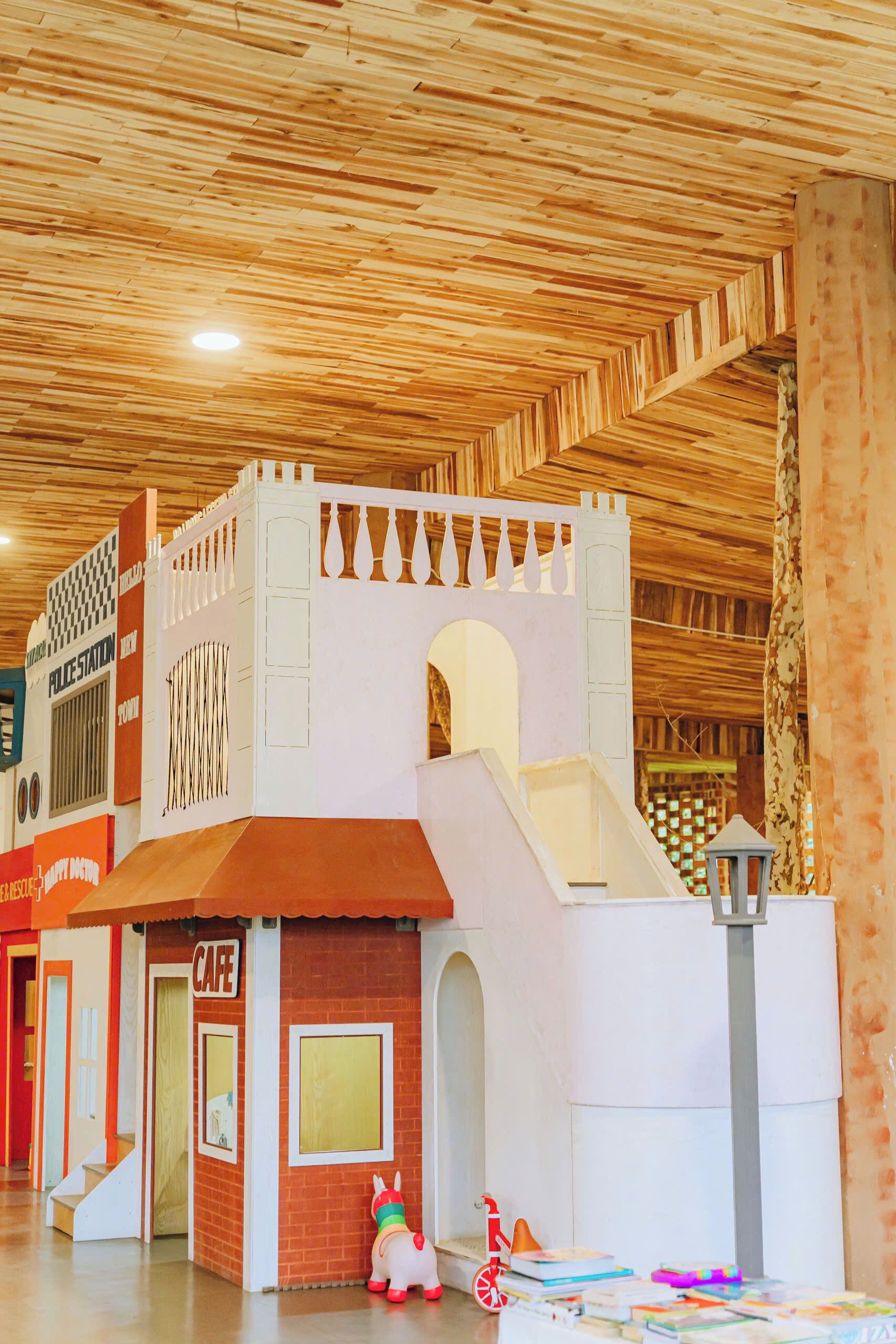 Un área de juegos con una estructura tipo castillo, un tobogán y una cafetería.