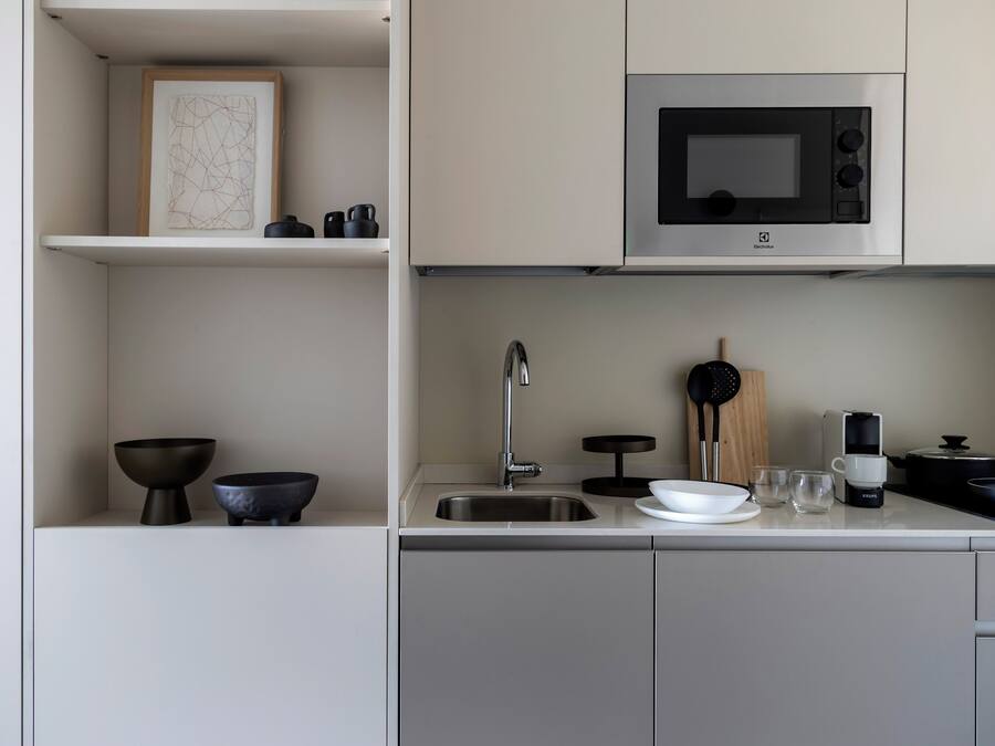A modern kitchen with a stainless steel sink, a microwave, and a coffee maker.