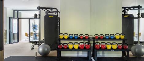 Ein Fitnessstudio mit Gewichten, Kettlebells und Trainingsbällen.
