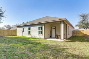 A single-story house with a front porch, a small attached garage, and a fenced backyard. - Easy Hwy Access to Dtwn: Pet-friendly Houston Home (Houston)