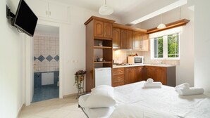 A modern kitchen with wooden cabinets, a built-in microwave, and a window. - Anna's One-Bedroom Apartment with Balcony, Wi-Fi and Air Conditioning (Νικιάνα)