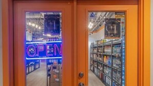 A store entrance with a sign reading "EPIC LIQUOR" and a neon "OPEN" sign. - Solara 2BR Retreat Pool- Hot Tub -113 (Canmore)