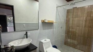 A modern bathroom with a sink, toilet, and shower. - hotel piedra grande (San Antonio del Tequendama)