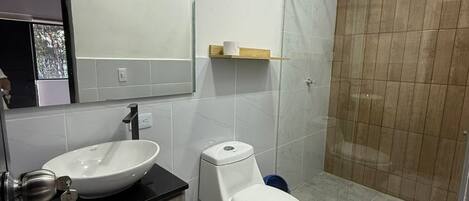 A modern bathroom with a sink, toilet, and shower.