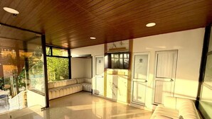 A spacious room with a large seating area, a kitchen with marble countertops, and large windows offering a view of greenery. - hotel piedra grande (San Antonio del Tequendama)