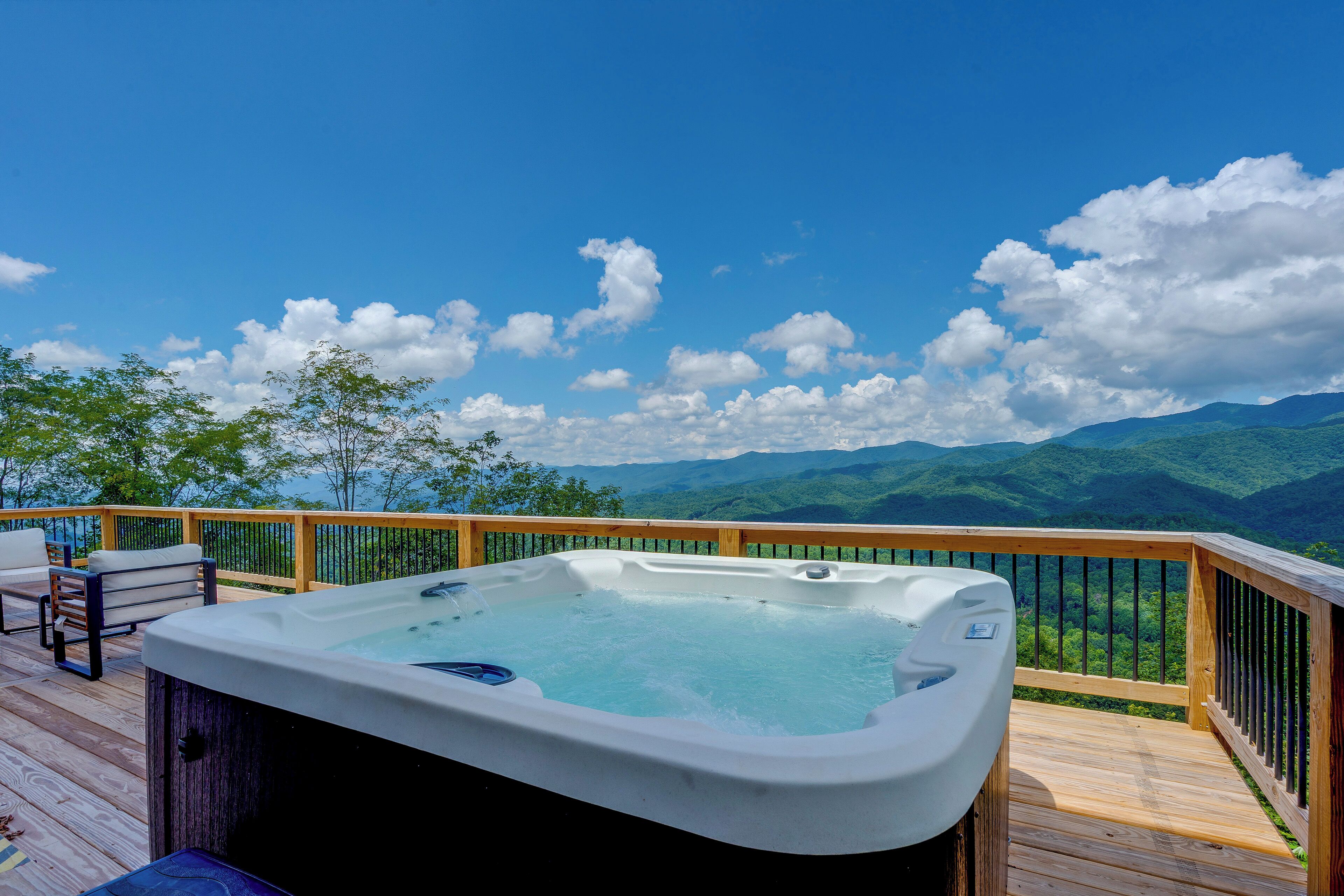 Ein Whirlpool auf einer Holzterrasse mit Blick auf die Berge.