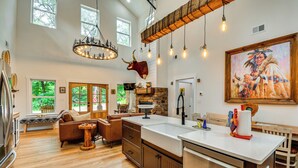 Una cocina amplia con una isla grande, piso de madera y una chimenea de piedra.