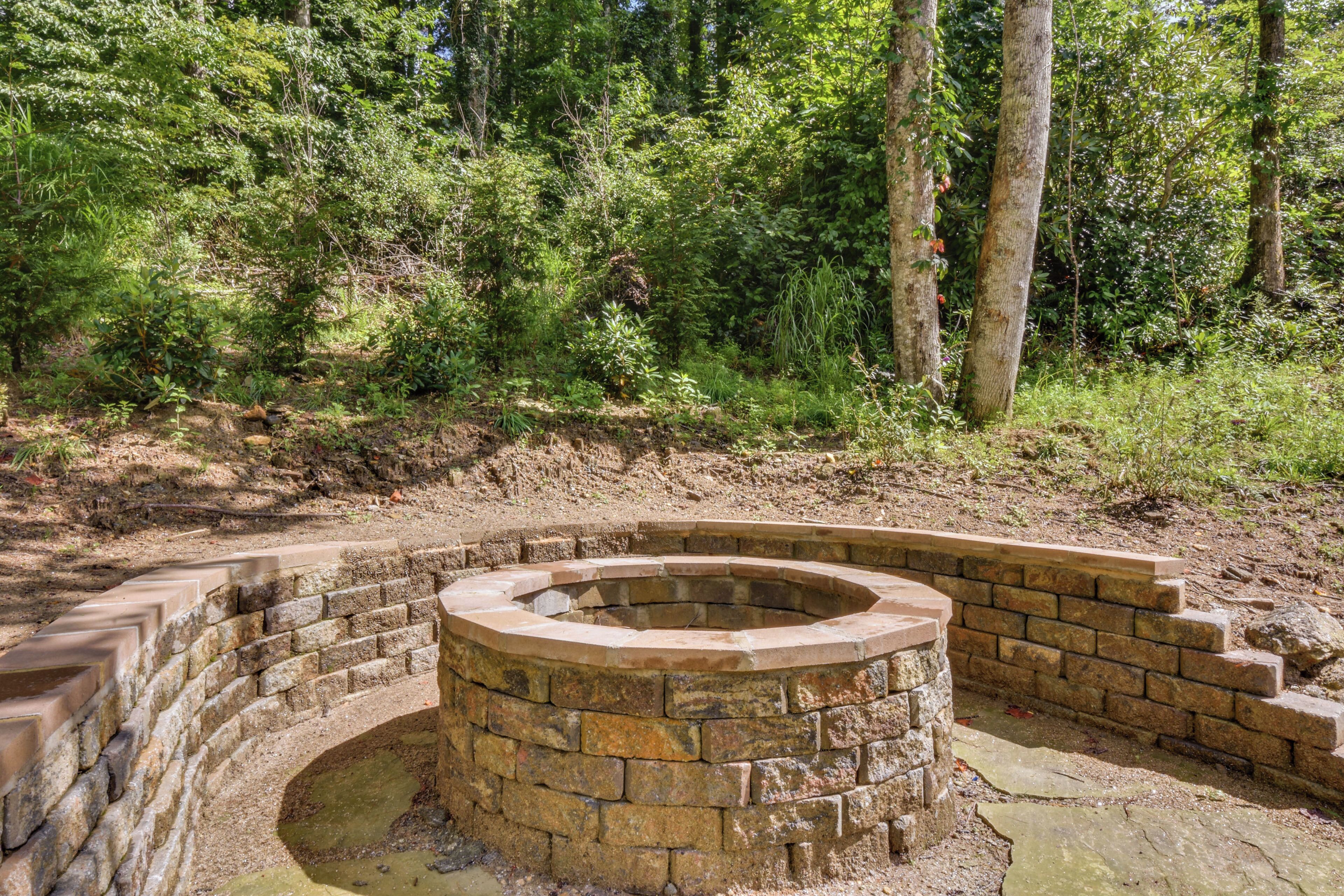 Een ronde stenen constructie, omgeven door een bakstenen muur, gelegen in een bebost gebied.