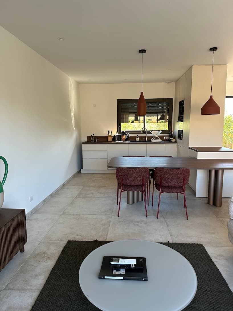 Una cocina moderna con comedor, una mesa redonda de centro y vistas al exterior.