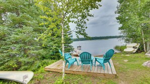 A wooden deck with outdoor seating and a view of a lake.