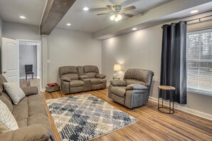 Un salon doté d’un ventilateur de plafond, de deux canapés inclinables, d’une table basse et d’un tapis.