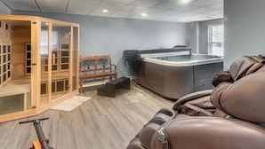 Ein Wellnessraum mit Massagegerät, Sauna und Holzschrank.