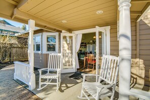 A covered porch with white rocking chairs and a bench, leading to a house with a visible kitchen and dining area. - Walk to Boat Launch! 'heritage House of Lakeport' (Lakeport)