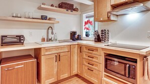 A modern kitchen with wooden cabinets, a built-in microwave, and a toaster. - Walk to The Oyster Bar: Chuckanut Dr Retreat! (Bow)