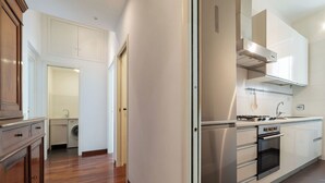 A modern kitchen with stainless steel appliances, wooden flooring, and white cabinetry. - Piazza Alessandria - FromHometoRome (Roma)
