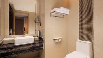 A bathroom with a sink, mirror, toilet, and towel rack.