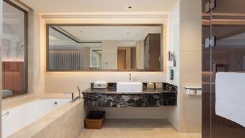Un baño moderno con un espejo grande, una bañera, un lavabo y una zona de ducha.