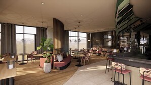 Eine großzügige Hotelhalle mit hohen Decken, großen Fenstern mit Blick auf die Berge und unterschiedlichen Sitzmöglichkeiten, darunter Sofas und Sessel.