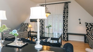 A cozy living room with a black and white striped sofa, a glass coffee table, and a white lamp. - 4 Star Holiday Home in Skanderborg (Skanderborg)