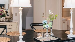 A dining table with placemats, candles, and a vase with flowers. - 4 Star Holiday Home in Skanderborg (Skanderborg)