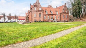A large brick building with multiple windows and a prominent tower. - 4 Star Holiday Home in Skanderborg (Skanderborg)
