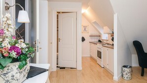 A modern kitchen with white cabinets, a wooden countertop, and a black chair. - 4 Star Holiday Home in Skanderborg (Skanderborg)