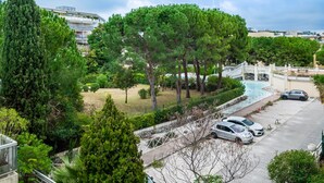 A residential area with a swimming pool, parked cars, and a bridge. - Le Lido Apartment – Beach, Pool, Parking, Sea View, Wi-Fi, Air Conditioning (Cagnes-sur-Mer)
