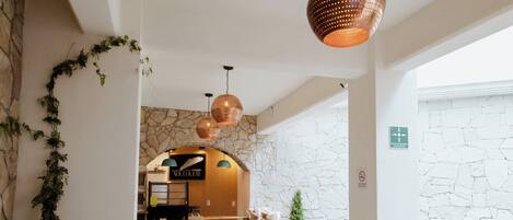 A dining area with wooden furniture and hanging copper pendant lights.