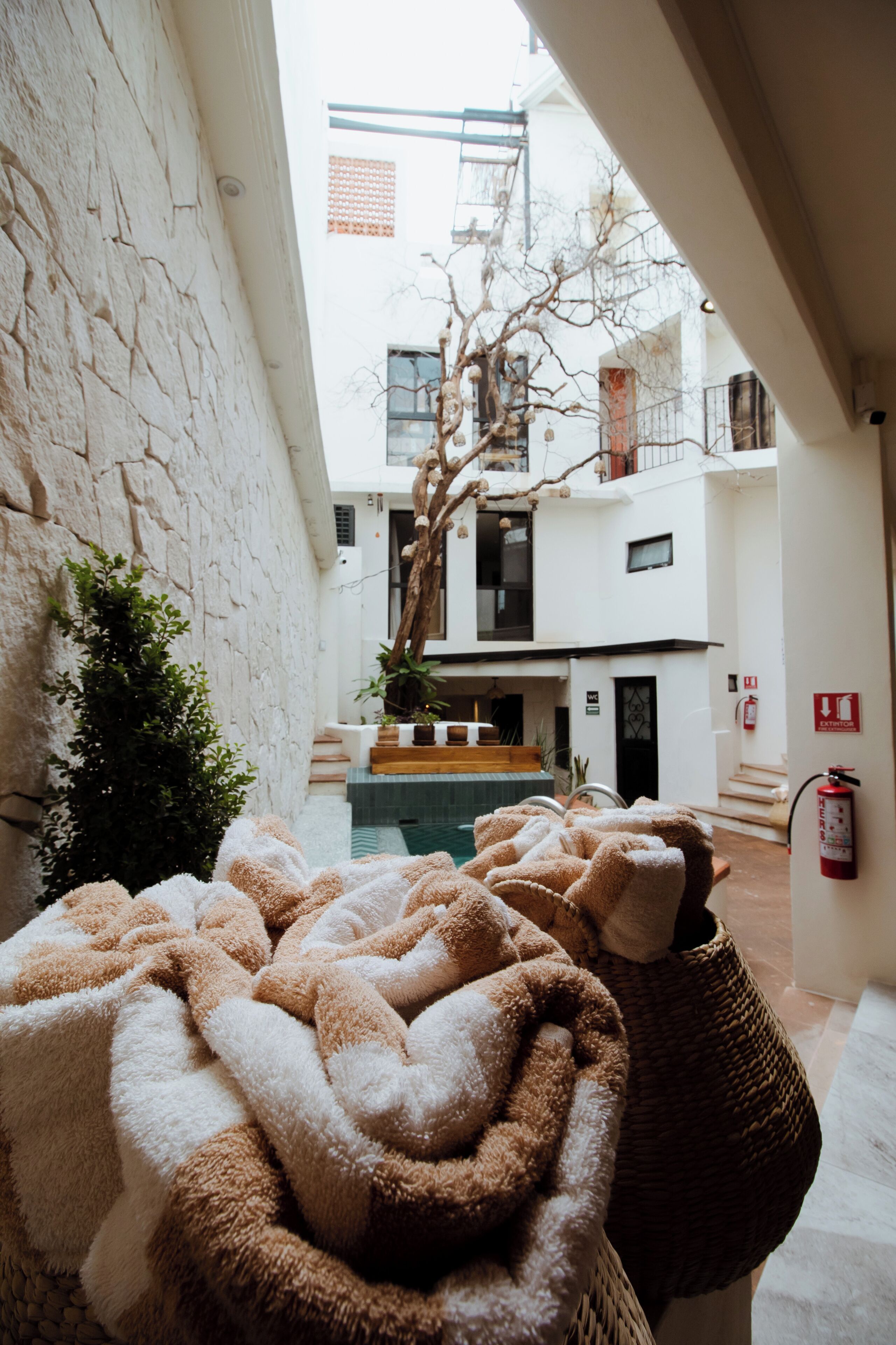 A cozy indoor space with a pool, a staircase, and a view of a building with balconies.