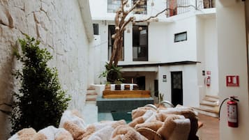 A cozy indoor space with a pool, a staircase, and a view of a building with balconies.