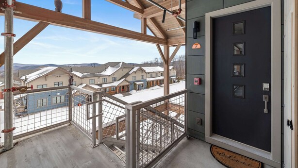 A balcony with a view of houses and a dark door with a number 7 sign. - Family Ski-In/Ski-Out at South Face Village (Ludlow)