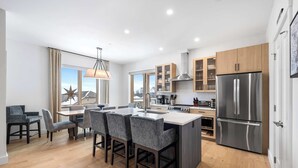 A modern kitchen with a central island, wooden cabinets, and stainless steel appliances. - Family Ski-In/Ski-Out at South Face Village (Ludlow)