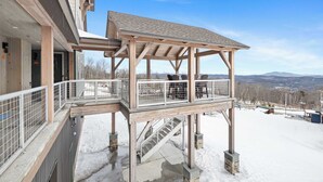 A wooden deck with a covered area and a staircase leading to a second level. - Family Ski-In/Ski-Out at South Face Village (Ludlow)
