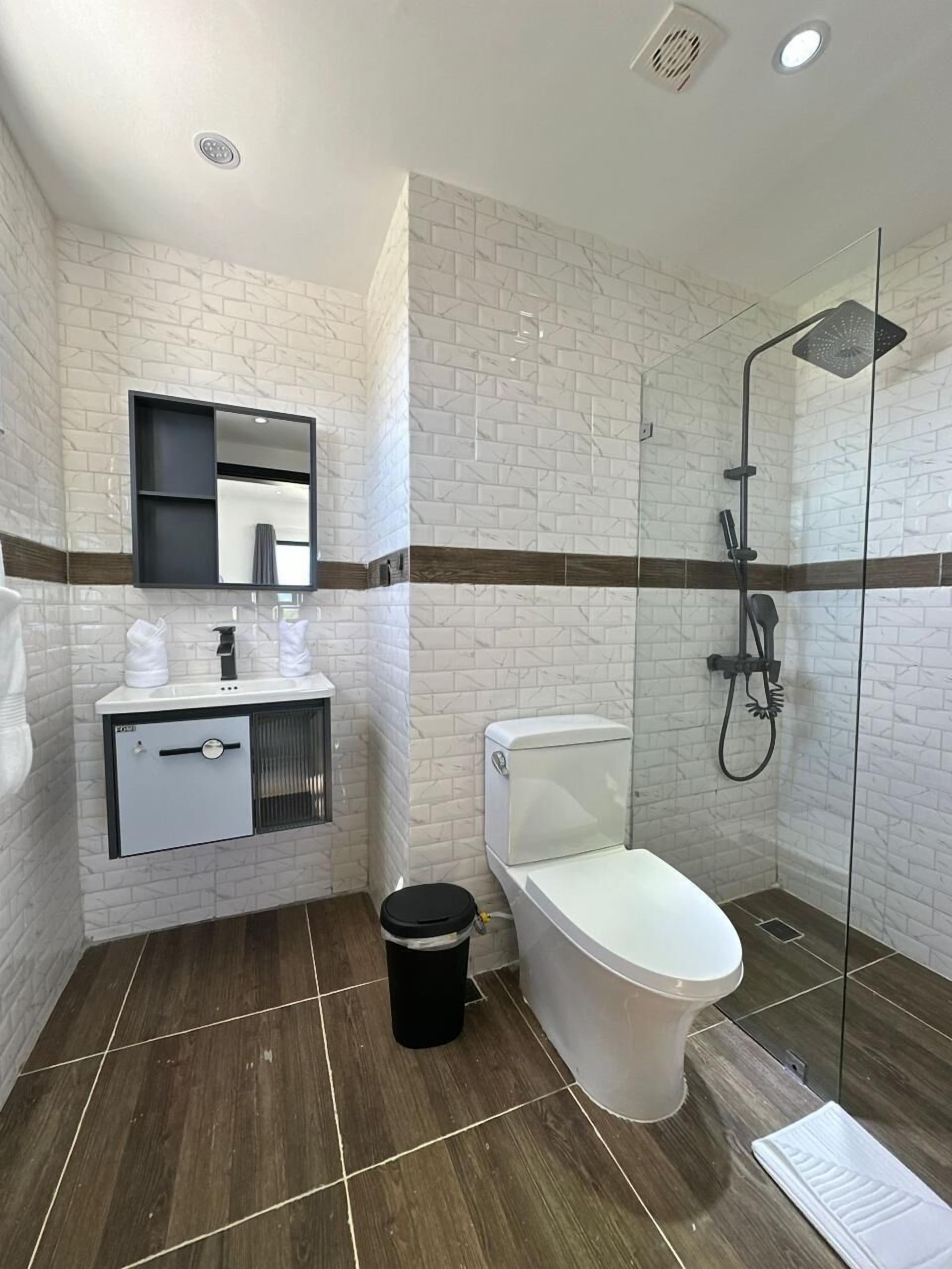 Familie penthouse | Badkamer | Een bad/douchecombinatie, handdoeken, zeep, shampoo