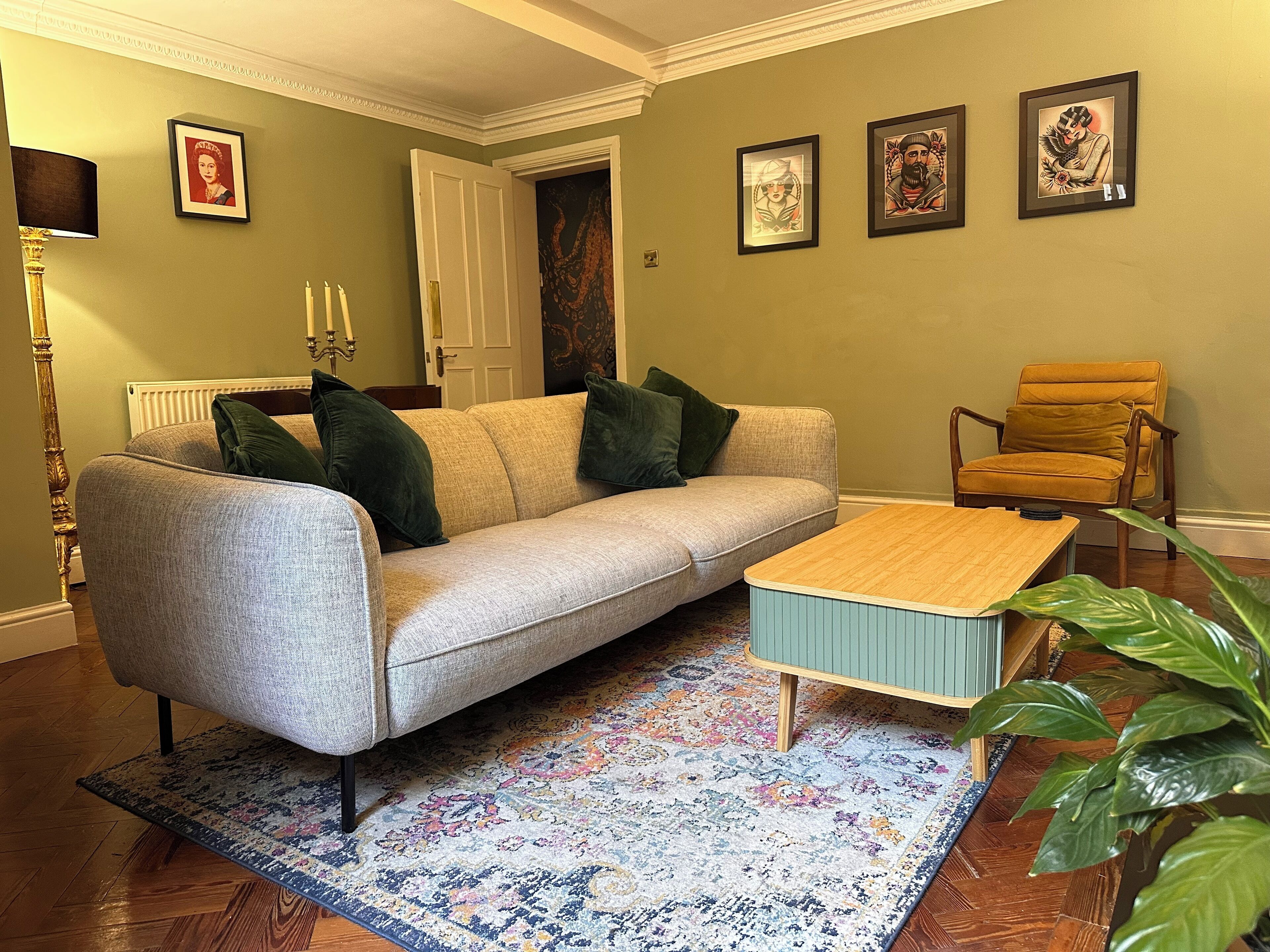 A living room with a sofa, a coffee table, a chair, and a patterned rug.