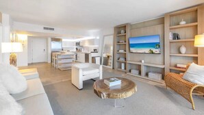 A modern living room with a sofa, coffee table, and a TV mounted on the wall. - 1 BR Suite @ 1 Hotel | Gym+Pool+Rooftop (Miami Beach)