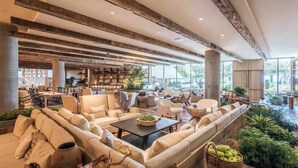 A spacious lounge area with sofas, a coffee table, and a bookshelf. - 1 BR Suite @ 1 Hotel | Gym+Pool+Rooftop (Miami Beach)