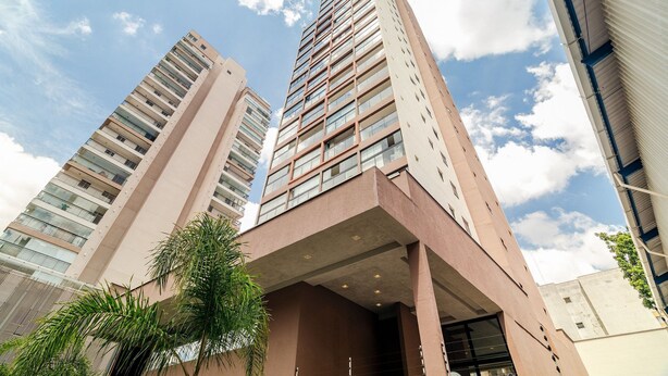 A tall building with multiple floors and balconies, surrounded by other high-rise buildings. - Ape Novo ao lado do Bourbon e Allianz. (São Paulo)
