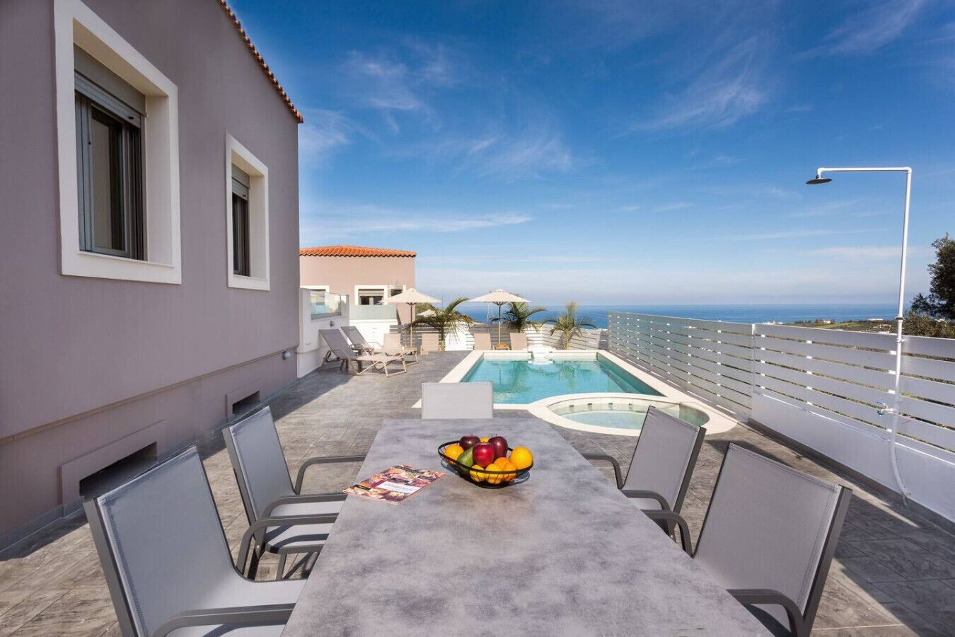 Eine Dachterrasse mit Pool, Sitzgelegenheiten im Freien und Meerblick.