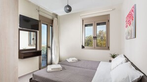 Une chambre à coucher avec un lit, une fenêtre, un miroir et une plante.