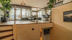 A modern interior with a staircase, a dining area, and a view of the outdoors. - Nova Houseboat Deluxe + free bikes (Amsterdam)