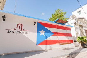 Una pared con una bandera y el texto 'SAN JUAN 901'.