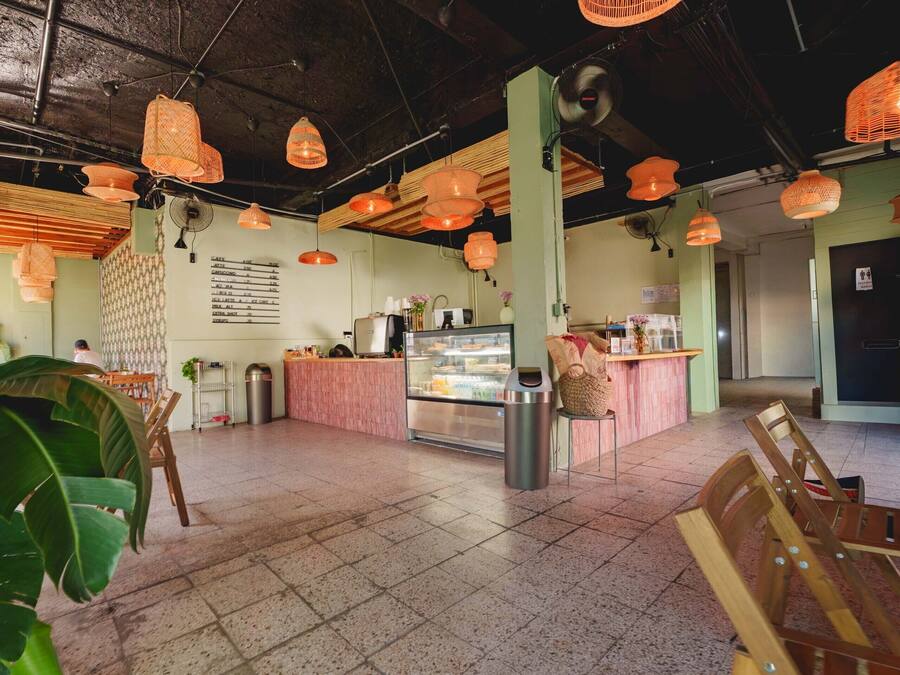 A cafe interior with a counter, seating area, and hanging orange lights.