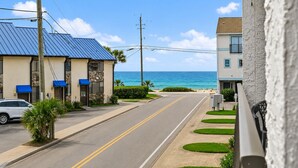 Eine Küstenstraße mit Gebäuden, einem klaren Himmel und dem Meer im Hintergrund.