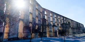 A large, historic stone structure with multiple arches and a paved area with trees. - Deluxe Suite Room with Shared Pool, Wi-Fi and Air Conditioning (Elvas)